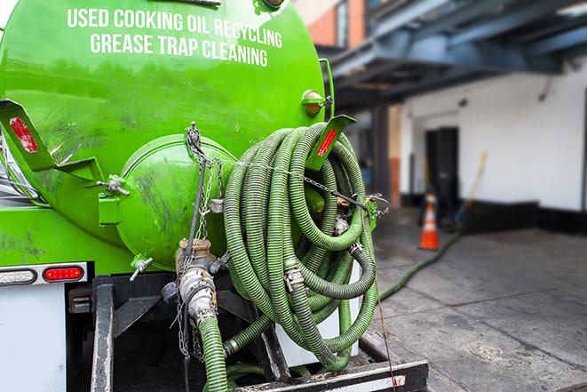 worker pumping grease trap at commercial kitchen in Brentwood